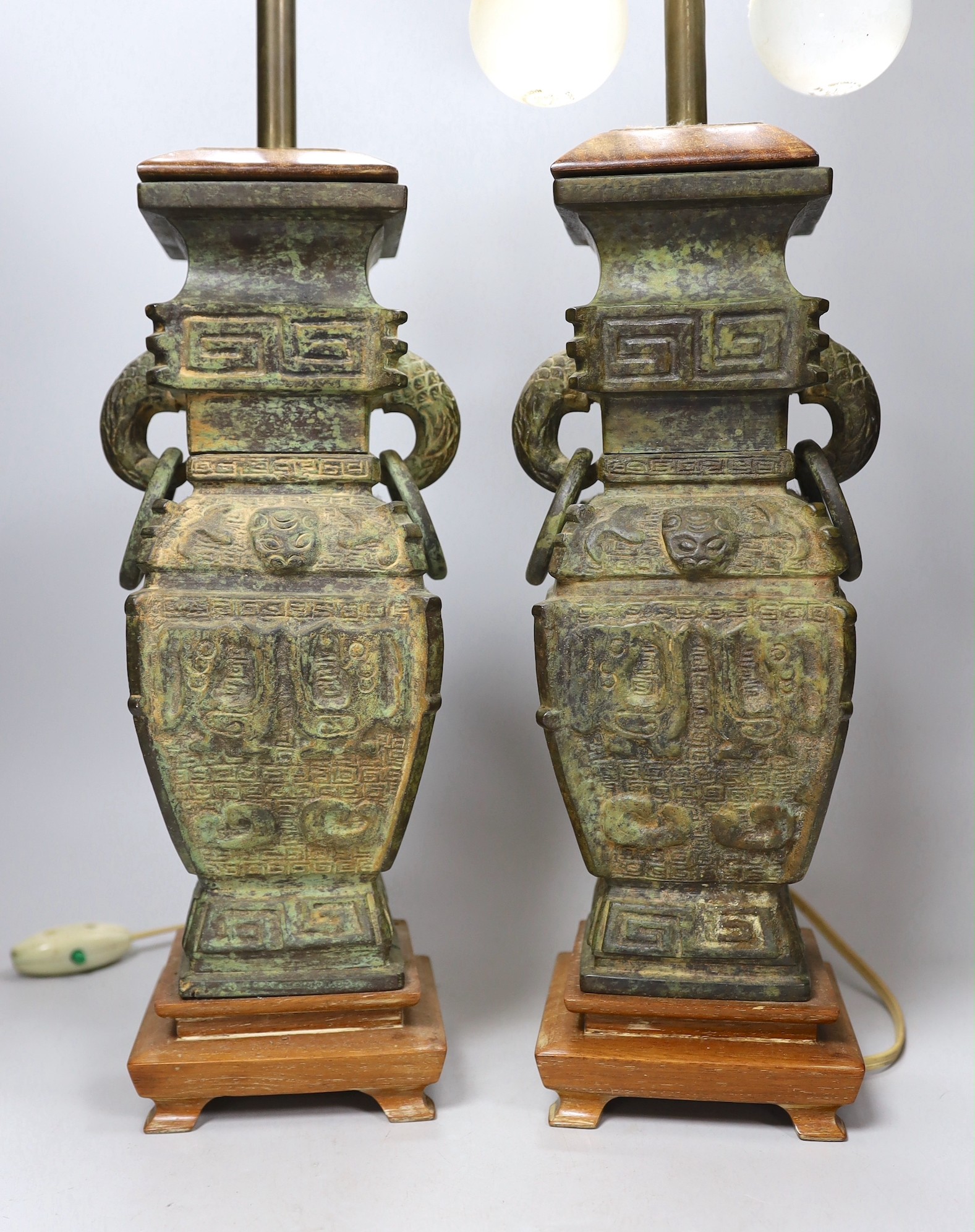 A pair of archaic Chinese bronze vases, converted into table lamps, 62cms high including light fitting